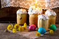 The traditional Easter treats: cakes and colorful easter eggs on a table in a rustic style.