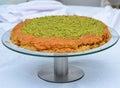 Traditional eastern dessert kunafa in a big vitreous dish isolated on white background. Top view.