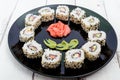Traditional eastern dish with salmon, shrimp - sushi rolls on a black plate Royalty Free Stock Photo