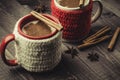 traditional eggnog in red and white mugs with cinnamon/traditional eggnog in red and white mugs with cinnamon on a dark background