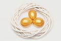 Traditional eggs painted in golden color inside woven wooden wreath Royalty Free Stock Photo