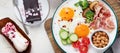 Traditional Englis breakfast plate with bacon strips, sunny side up eggs, vegetables and cake on light background Royalty Free Stock Photo