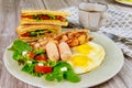 Traditional English breakfast with bacon, eggs, sausages, salad and grilled cheese toast Royalty Free Stock Photo