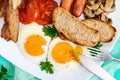 Traditional English breakfast: bacon, mushrooms, eggs, tomatoes, sausages, beans, toast on a white plate Royalty Free Stock Photo