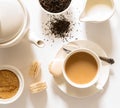 Traditional English breakfast black tea with milk -tea leaves. teacup, teapot, sugar and milk bowls, macaroons sweets on a white