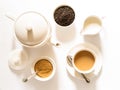 Traditional English breakfast black tea with milk -tea leaves. teacup, teapot, sugar and milk bowls on a white background, top