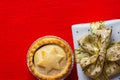 Traditional English Christmas dessert pastry mince pie in muffin tins sprinkled with sugar gift box with golden ribbon Royalty Free Stock Photo