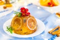 Traditional English Christmas pudding decorated with oranges and fresh flowers in a festive table setting with fruits Royalty Free Stock Photo