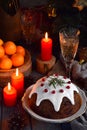 Traditional english Christmas steamed pudding with winter berries, dried fruits, nut in festive setting with Xmas tree, burning ca Royalty Free Stock Photo