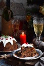 Traditional english Christmas steamed pudding with winter berries, dried fruits, nut in festive setting with Xmas tree, burning ca Royalty Free Stock Photo