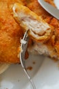 Traditional english dish with battered white cod, french fries and fresh vegetable served on a white plate