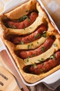Traditional English dishes toad in the hole close-up vertical to Royalty Free Stock Photo
