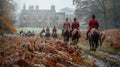 Traditional english Fox hunters are galloping on field in red hunting suits, hunting dogs running next to horses. Royalty Free Stock Photo