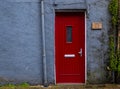 Traditional English house facade front entrance with red closed door . Royalty Free Stock Photo