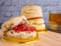 Traditional English style scones delicious freshly baked homemade with strawberry jam on a plate placed on wooden cutting board Royalty Free Stock Photo