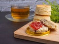 Traditional English style scones delicious freshly baked homemade with strawberry jam on a plate on wooden cutting board Royalty Free Stock Photo