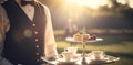 Traditional English tea time, cups, crockery, food and desserts served by a waiter at formal English garden, estate or Royalty Free Stock Photo