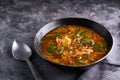 Traditional European and Russian soup borsch with cabbage and meat served in a plate on a dark stone table