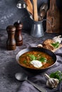 Traditional European and Russian soup borsch with cabbage, sour cream and meat served in a plate on a dark stone table