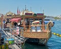 Traditional fast food bobbing boat serving fish sandwiches at Eminonu with chefs preparing meals, Istanbul, Turkey