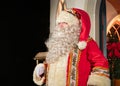 UK, Belfast - Dec 2012: Traditional Father Christmas character outside a brightly lit christmas house