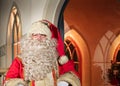 UK, Belfast - Dec 2012: Traditional Father Christmas character outside a brightly lit chritmas house