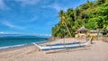 A wooden outrigger boat on a tropical island beach in the Philippines.