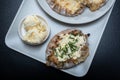 Traditional Finnish foods - Fresh Karelian pies with rice pudding filling and egg butter and chives topping against black Royalty Free Stock Photo