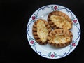 Traditional Finnish Karelian pies on a plate with black background and copy space