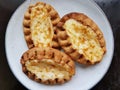 Traditional Finnish Karelian pies on a plate with black background.