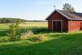 Traditional Finnish red wooden barn with roundpole fence Royalty Free Stock Photo