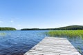 Traditional Finnish view. Beautiful calm lake on a summer morning and an old rustic wooden pier. Royalty Free Stock Photo