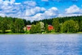 A traditional Finnish wooden cottage with a sauna and a barn on the lake shore. Summer rural Finland. Royalty Free Stock Photo