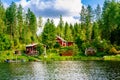 A traditional Finnish wooden cottage with a sauna and a barn on the lake shore. Summer rural Finland. Royalty Free Stock Photo