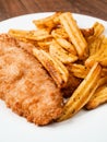 Traditional fish and chips dish on white plate. Common take away meal in English speaking nations. Cooked cod with peppered potato Royalty Free Stock Photo