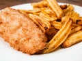 Traditional fish and chips dish on white plate. Common take away meal in English speaking nations. Cooked cod with peppered potato Royalty Free Stock Photo