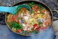 Traditional fisherman`s soup over a campfire. Ukha of fish and v