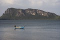 Traditional fishing boat laying on a beach near the sea with big and long mountain in background,cloudy sky,filtered image Royalty Free Stock Photo