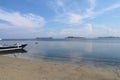 Traditional fishing boat moored at sandy beach using an anchor rope. Laminate boat with wooden roof tied up by shore at low tide. Royalty Free Stock Photo