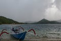 Traditional fishing boat moored at sandy beach using an anchor rope. Laminate boat with wooden roof tied up by shore at low tide. Royalty Free Stock Photo