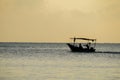 Traditional fishing boat silhouettes over sunrise