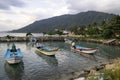 Traditional fishing boats at the pier of Koh Phangan island in Thailand at sunset on a cloudy day Royalty Free Stock Photo