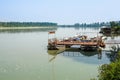 Traditional fishing boats tied up on the floating dock in picturesque surrounding of the big river Royalty Free Stock Photo