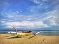 A traditional fishing canoe on the beach during the low tide.