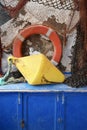 Traditional fishing equipment of life saver ring, weight, ropes and nets on blue wooden chest Royalty Free Stock Photo