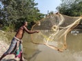 Traditional fishing by a fisherman throwing a spinning net in a pond Royalty Free Stock Photo