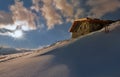 alpine chalet at the top of snowy mountain at sunset Royalty Free Stock Photo