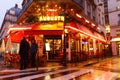 The traditional French cafe Auguste decorated with flowers at rainy night . It located at famous Rivoli street in Paris, France Royalty Free Stock Photo