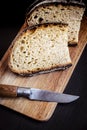 Traditional French country bread slices and pocket knife on a cutting board Royalty Free Stock Photo