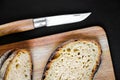 Traditional French country bread slices and pocket knife on a cutting board Royalty Free Stock Photo